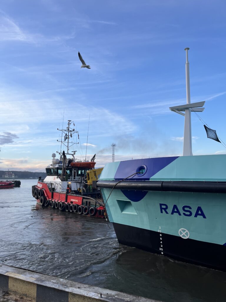 A convoy of tug and waste collection tanker hull leaving the port of Klaipeda